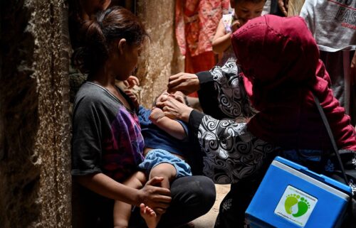 A health worker administers a polio vaccine to a child in a downtown area of Lahore