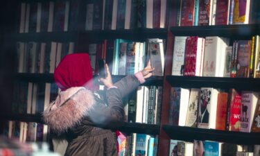 A shopper photographs a book inside a Barnes & Noble bookstore in New York