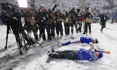 A person clears the snow from the sidewalk in Lowville