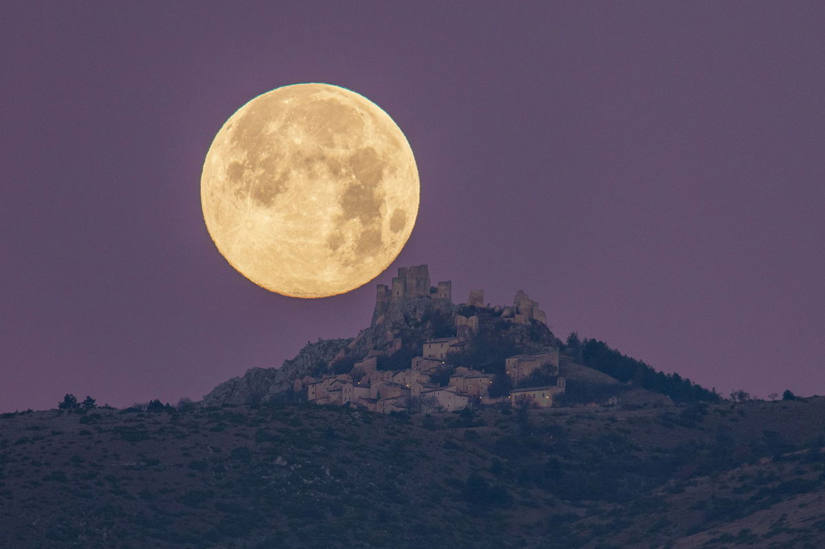 <i>Lorenzo Di Cola/NurPhoto/Shutterstock via CNN Newsource</i><br/>The cold moon sets behind Rocca Calascio castle and village in Calascio