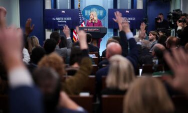 Members of the media raise their hands as White House press secretary Karoline Leavitt delivers remarks during her first daily briefing.