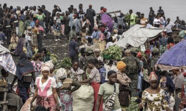 Sellers and residents move through a market under the supervision of members of the M23 armed group at a port along Lake Kivu as the community gradually returns to the streets of Goma on January 31.