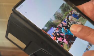 Reza Hasani shows a photo from a USAID International Women's Day event in Afghanistan.