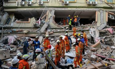 Rescue teams work to evacuate residents trapped under the rubble of a collapsed building in Mandalay