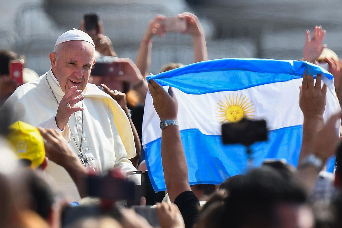 <i>Vincenzo Pinto/AFP/Getty Images via CNN Newsource</i><br/>A worshiper waves the flag of Argentina as Pope Francis arrives for the weekly general audience on June 5