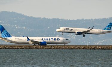 A United Airlines plane prepares for takeoff as a JetBlue plane lands at San Francisco International Airport in 2023.