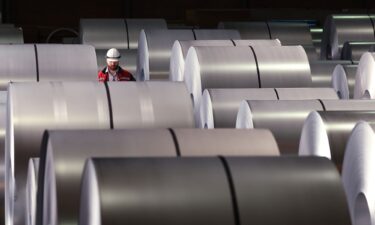 A worker walks among coils of finished steel at a plant in Duisburg
