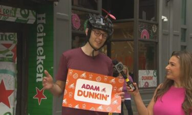 Adam Bigelow holds one of the signs that Dunkin' made in support of his ride.