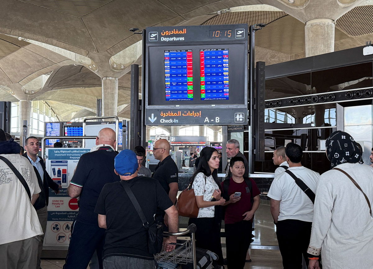 <i>Reuters via CNN Newsource</i><br/>People stand in front of a flight information display screen showing information about delayed and canceled flights at Queen Alia International Airport in Amman