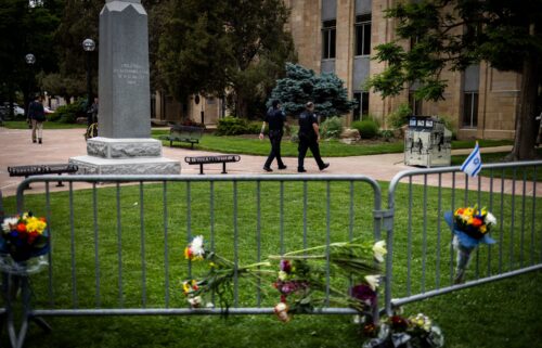 An Israeli flag is fixed to a street sign as police stand by off Pearl Street in Boulder