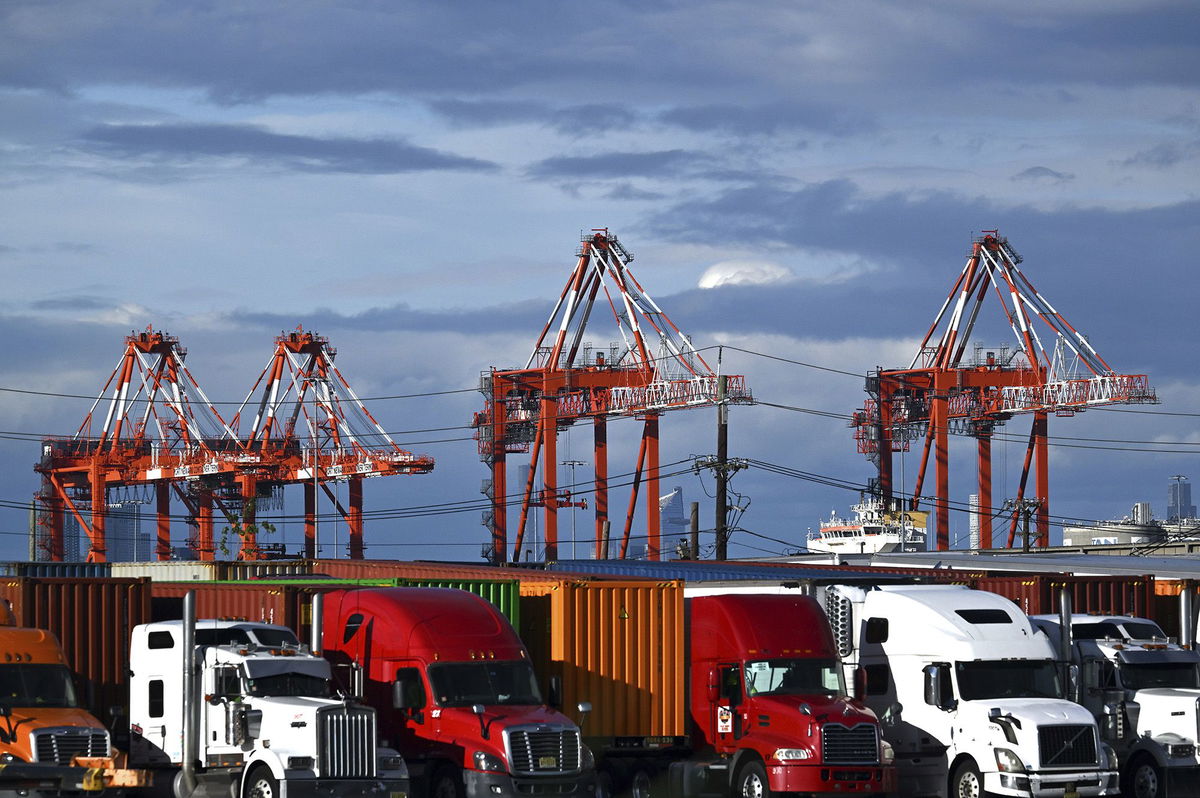 <i>Anthony Behar/Sipa USA/AP via CNN Newsource</i><br/>View of shipping cranes seen behind trucks and shipping containers at a port in Elizabeth