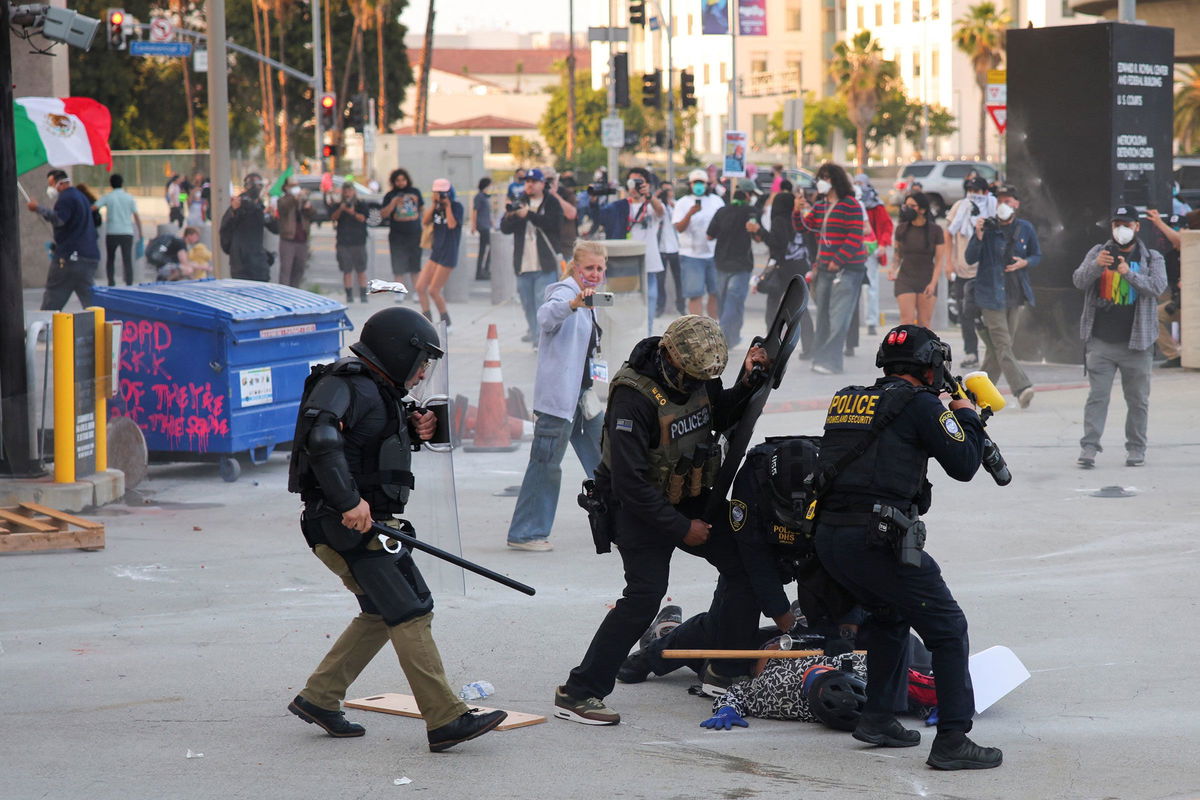 Police detain a protester blocking the garage entrance of the Los Angeles Federal Building, following multiple detentions by Immigration and Customs Enforcement, in downtown Los Angeles on Friday.