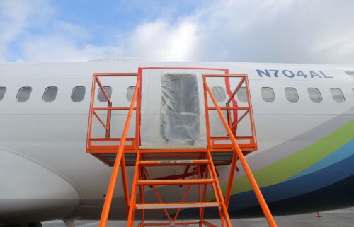 Plastic covers the exterior of the fuselage plug area of Alaska Airlines Flight 1282 Boeing 737-9 MAX in January 2024 in Portland