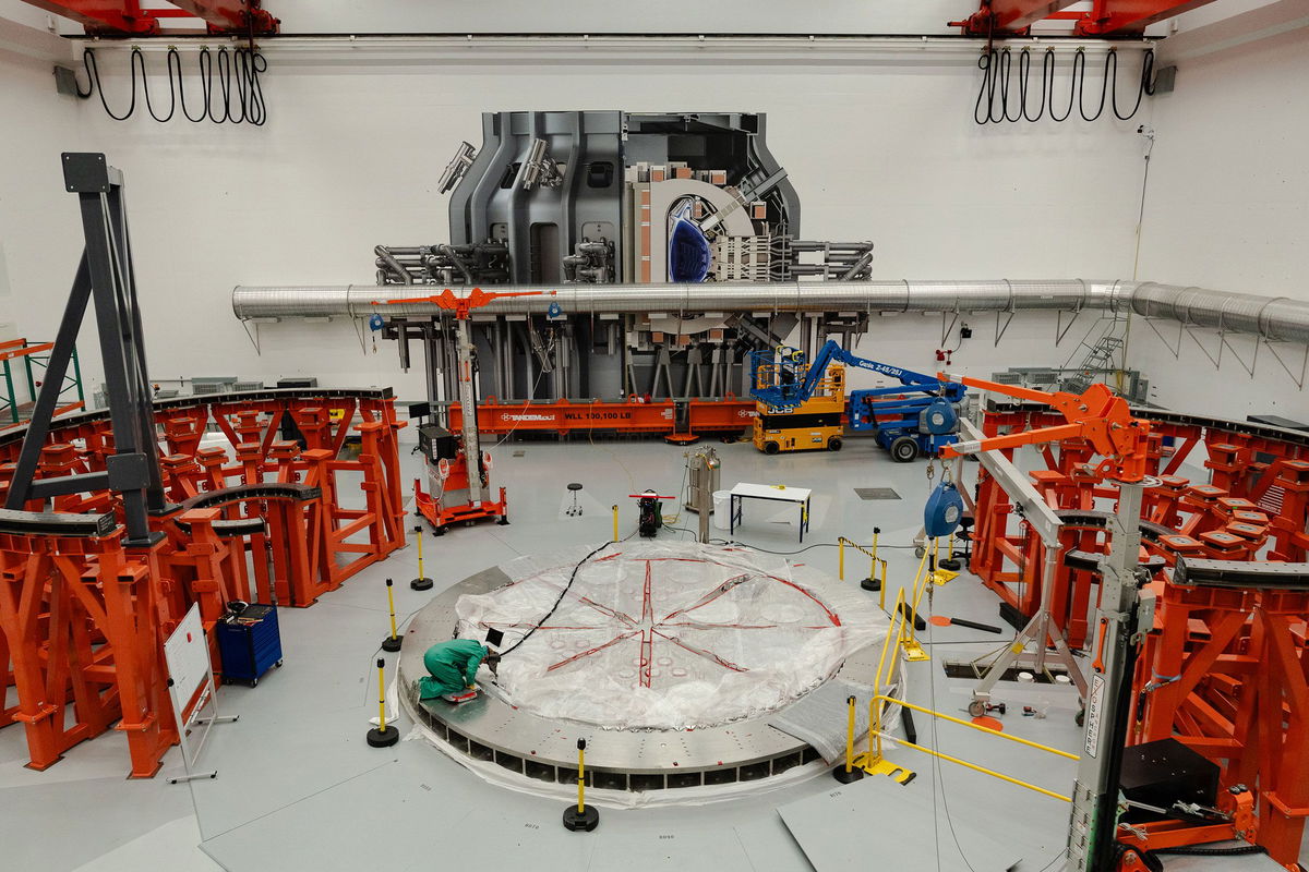 <i>Sophie Park for CNN via CNN Newsource</i><br/>A person works on the cryostat base of the fusion reactor inside the tokamak hall at Commonwealth Fusion Systems in Devens