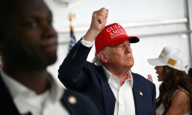 President Donald Trump waves as he visits a migrant detention center