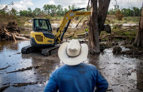 Machinery is used to clear debris along the banks of the Guadalupe River after catastrophic floods in Center Point