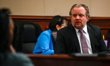 James Craig talks with his family from his seat before opening arguments in his murder trial at the Arapahoe District Court on July 15 in Centennial