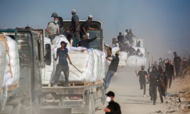 Palestinians carry aid parcels west of Beit Lahia in Gaza on July 29.