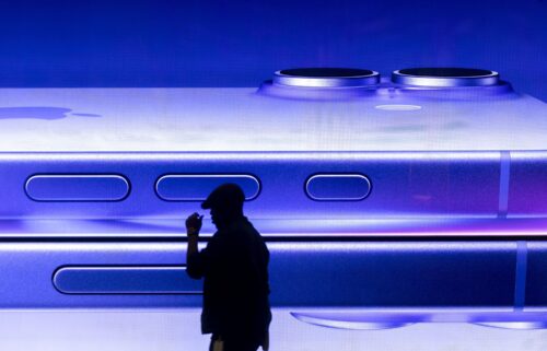 A man walks past an advertisement for an iPhone at an Apple store in central London